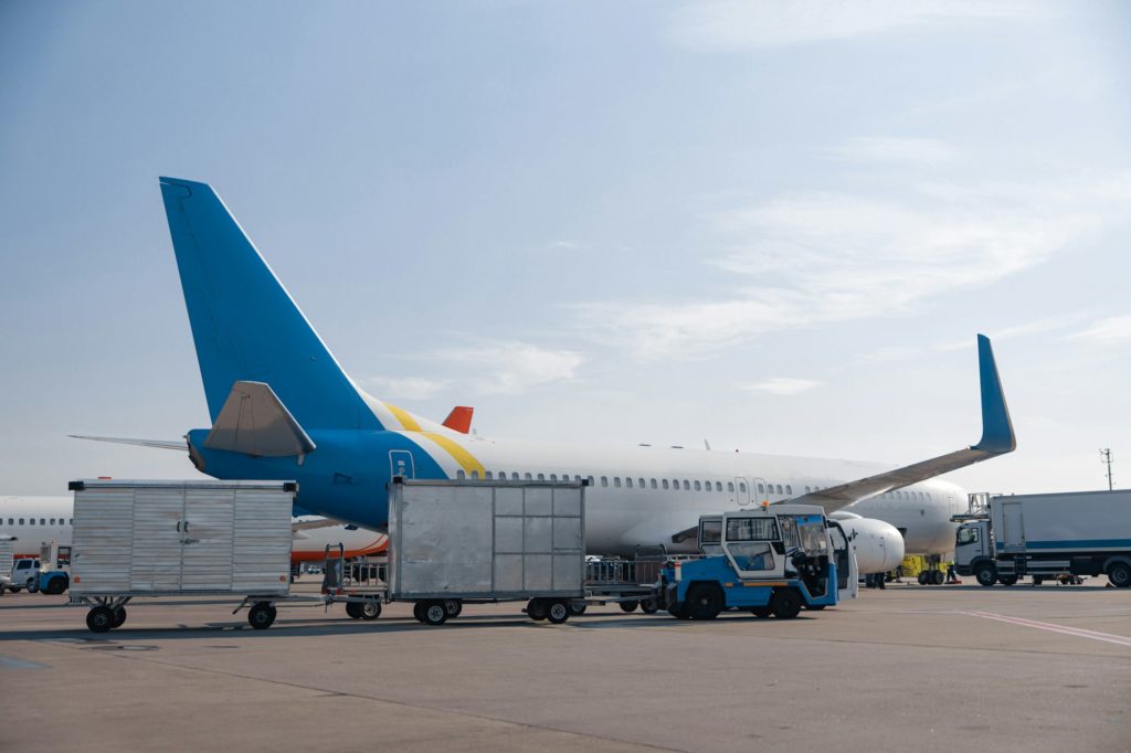 Airfield tractors near big modern airplane ready for boarding in airport hub on a daytime