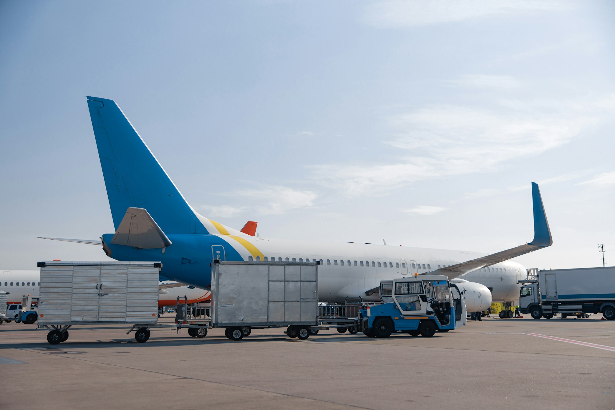 Airfield tractors near big modern airplane ready for boarding in airport hub on a daytime